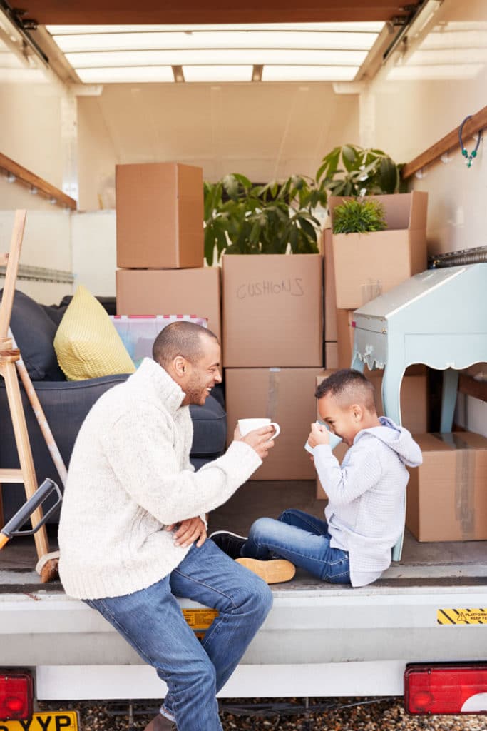 Father and Son in moving truck drinking out of a mug